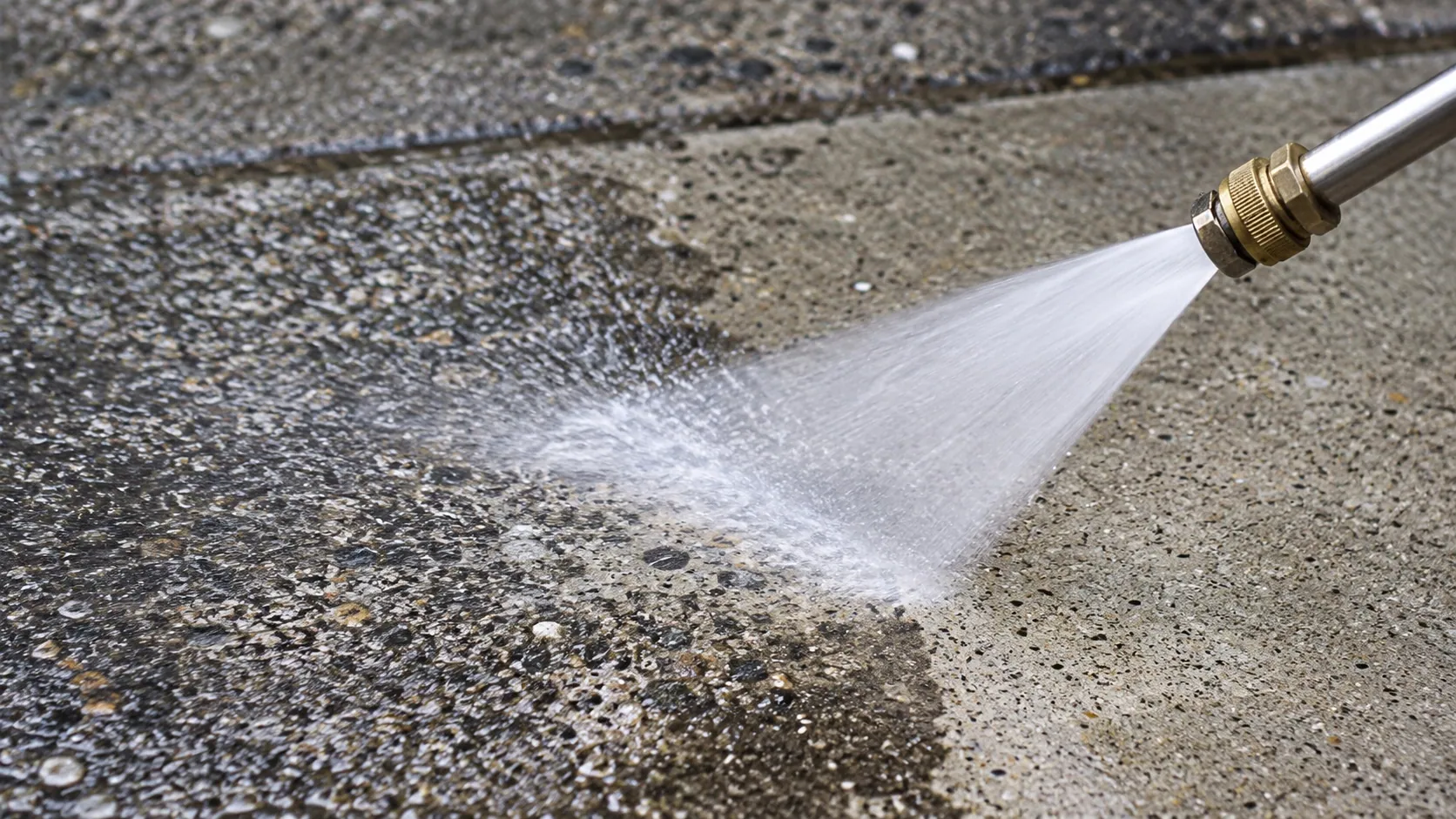 A fan of water meeting textured gray concrete in close-up