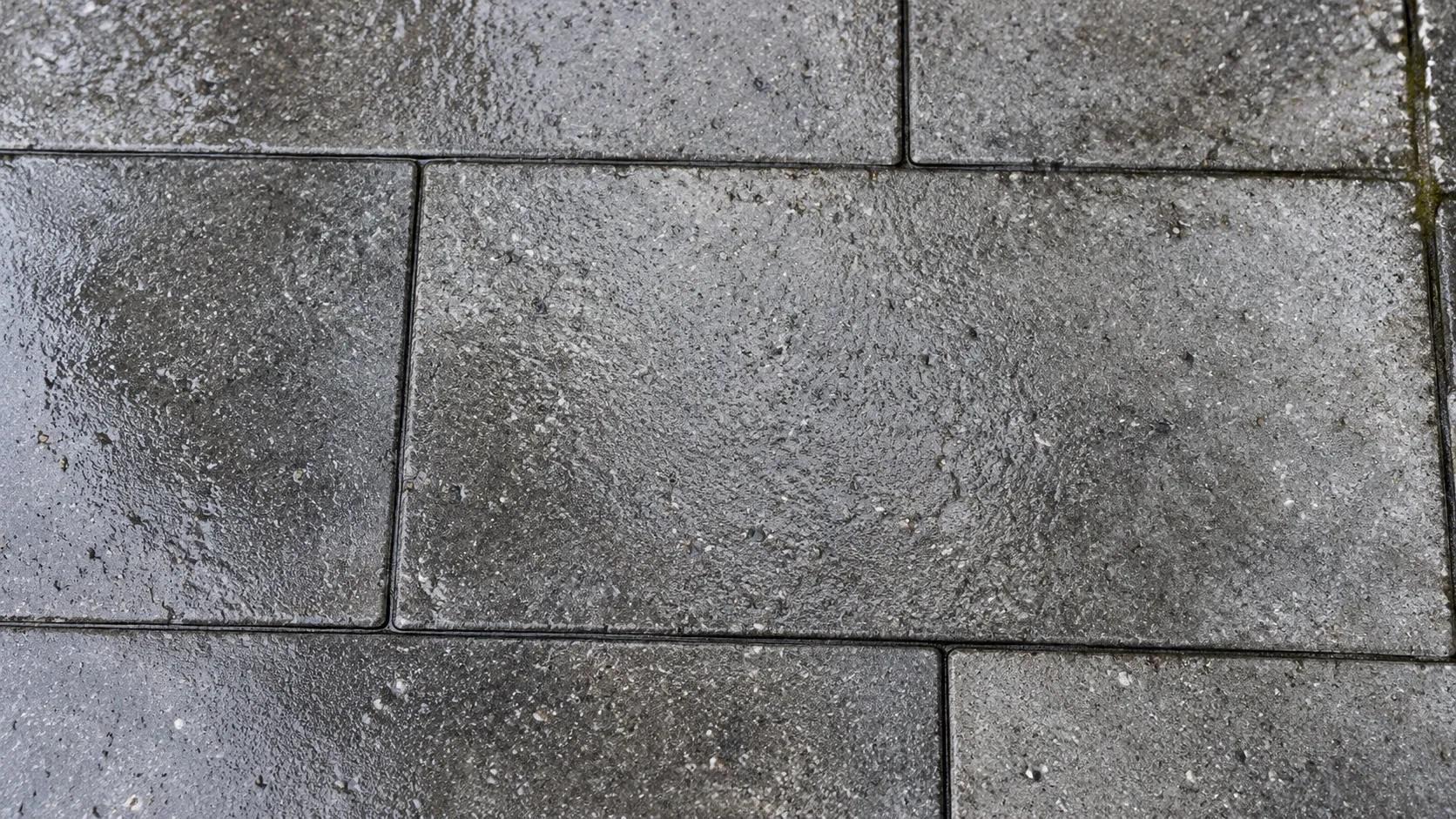 Overhead detail of gray patio pavers with wet mineral texture